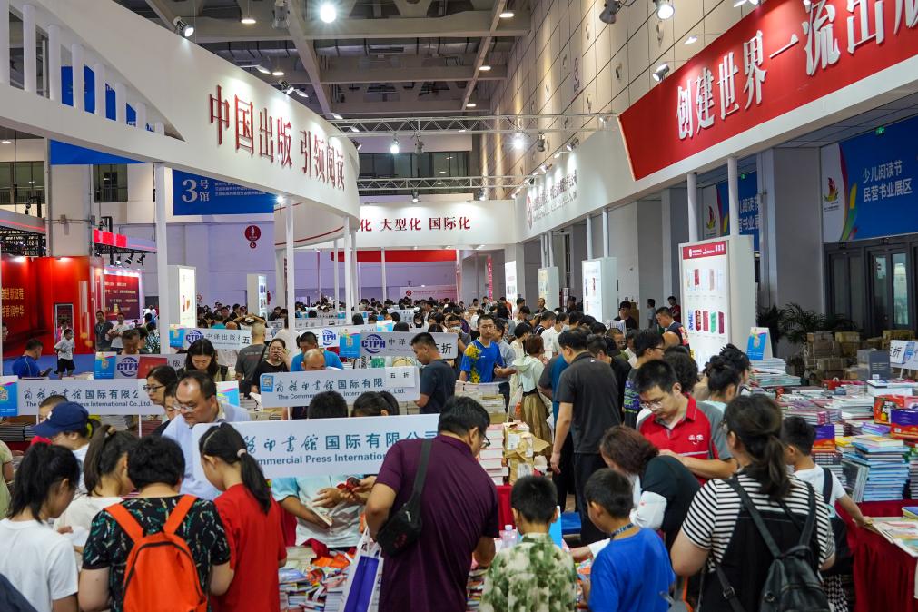 2023年7月31日,在第31届全国图书交易博览会上,读者在阅览选购新书。新华社记者 朱峥 摄